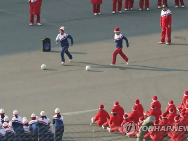 ボールを蹴りながら競争する北朝鮮応援団のメンバー＝１６日、麟蹄（聯合ニュース）