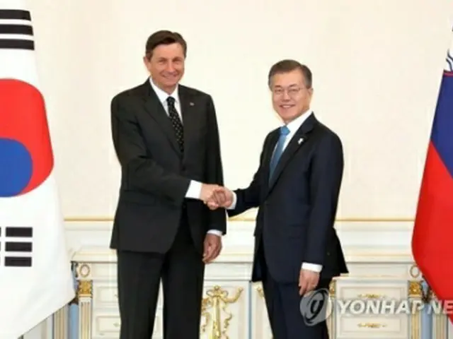 握手を交わす文大統領（右）とパホル大統領＝２０日、ソウル（聯合ニュース）