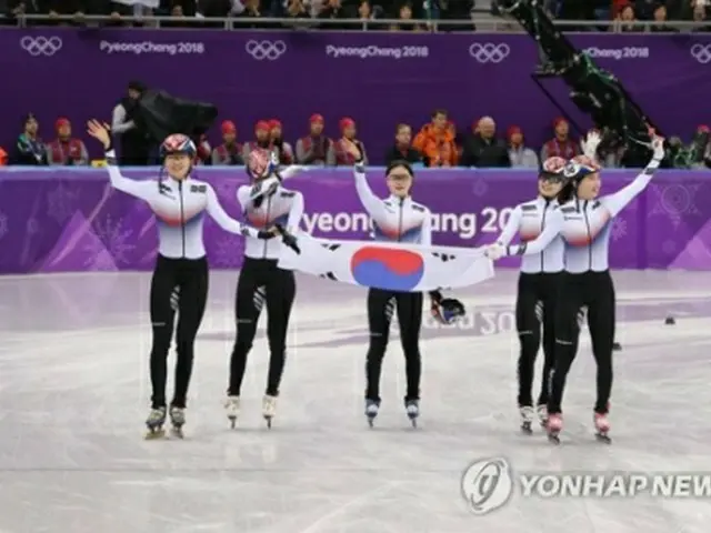 競技を終え、韓国国旗を手に観客の声援に応える韓国選手＝２０日、江陵（聯合ニュース）