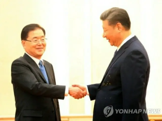 握手を交わす鄭義溶国家安保室長（左）と習近平中国国家主席＝１２日、北京（聯合ニュース）