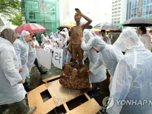 市民団体が行った総領事館前に像の模型を設置するパフォーマンスの様子＝２４日、釜山（聯合ニュース）