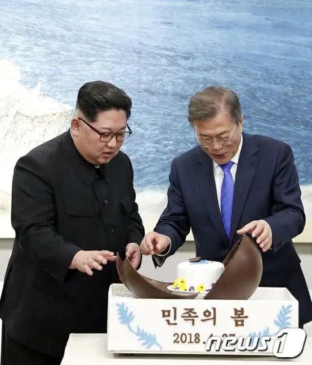 昨夜の晩餐でデザートを開封して中身をじっくり見ている北朝鮮の金正恩党委員長と韓国の文在寅大統領。（提供:news1）