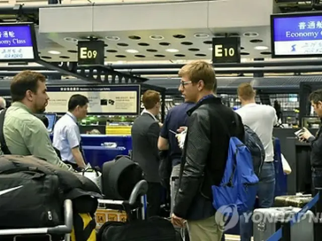 北京の空港でチェックインカウンターに並ぶ外国記者ら＝２２日、北京（ＡＰ＝聯合ニュース）