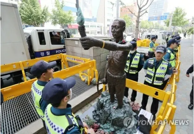 像を取り囲んで警戒を続ける警察＝３０日、釜山（聯合ニュース）
