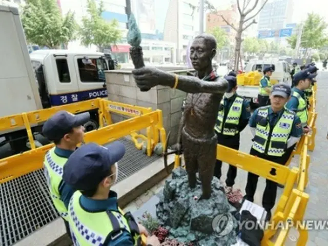 像を取り囲んで警戒を続ける警察＝３０日、釜山（聯合ニュース）