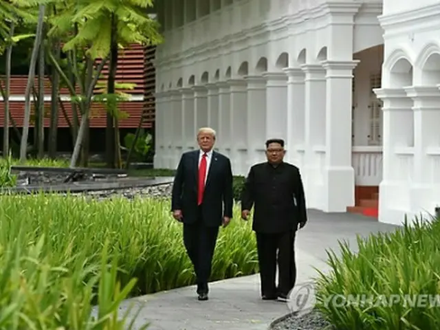 昼食会後、ホテルで散歩する金委員長（右）とトランプ大統領＝12日、シンガポール（AFP＝聯合ニュース）