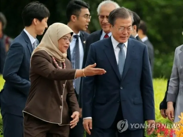 公式歓迎式でハリマ・ヤコブ大統領の案内を受ける文大統領（右）＝１２日、シンガポール（聯合ニュース）