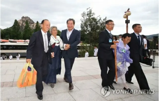 韓国の家族との個別面会のため、手を取り合ってホテルに入る北朝鮮の家族（ニュース通信取材団）＝２１日、金剛山（聯合ニュース）