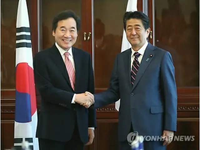 握手を交わす李首相（左）と安倍首相＝１１日、ウラジオストク（聯合ニュース）