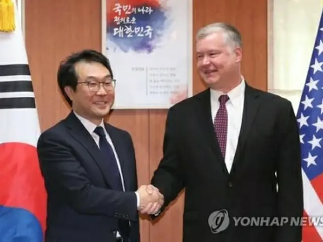李度勲・朝鮮半島平和交渉本部長（左）と握手するビーガン氏＝１１日、ソウル（聯合ニュース）