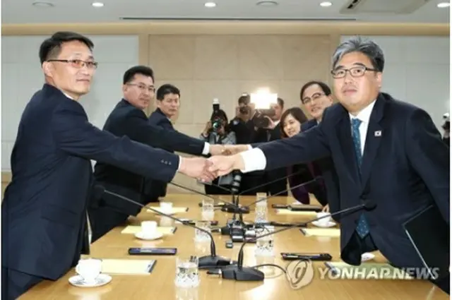 握手を交わす韓国（右側）と北朝鮮の代表団（写真共同取材団）＝２２日、開城（聯合ニュース）