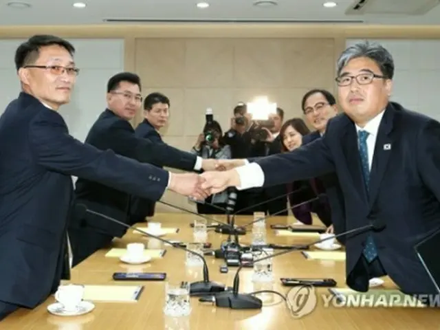握手を交わす韓国（右側）と北朝鮮の代表団（写真共同取材団）＝２２日、開城（聯合ニュース）