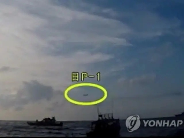 遭難した漁船を救助する韓国の艦艇の上空を日本の哨戒機（黄色の丸）が低高度で飛行する様子を韓国海洋警察が撮影した（国防部ユーチューブより）＝４日、ソウル（聯合ニュース）