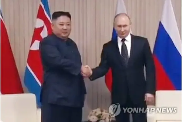 初の会談で握手を交わす北朝鮮の金正恩（キム・ジョンウン）国務委員長（朝鮮労働党委員長）とロシアのプーチン大統領（聯合ニュースTVの映像画面より）＝２５日、ソウル（聯合ニュース）