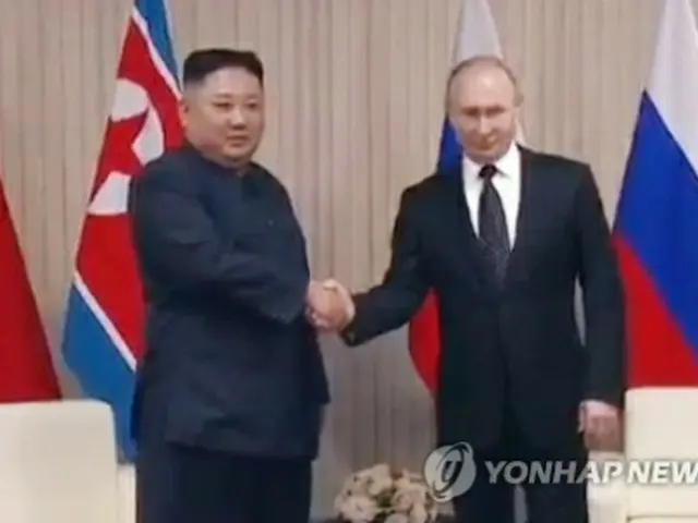 初の会談で握手を交わす北朝鮮の金正恩（キム・ジョンウン）国務委員長（朝鮮労働党委員長）とロシアのプーチン大統領（聯合ニュースTVの映像画面より）＝２５日、ソウル（聯合ニュース）