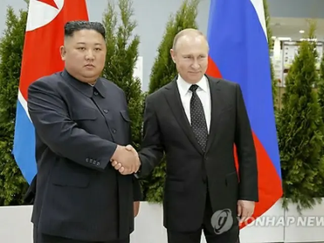 握手を交わす金委員長（左）とプーチン大統領＝２５日、ウラジオストク（ＡＰ＝聯合ニュース）