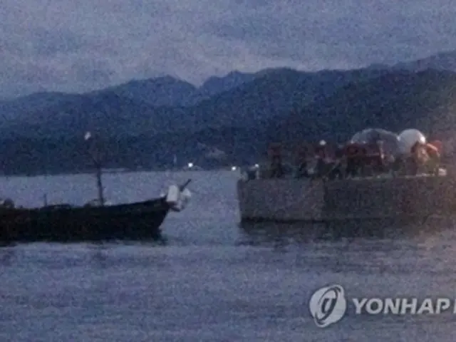 韓国の艦艇によりえい航される木造船（左、軍合同参謀本部提供）＝29日、ソウル（聯合ニュース）《転載・転用禁止》