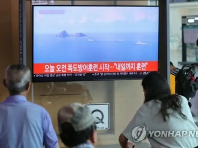 韓国軍が独島防衛のための訓練を開始した２５日、ソウル駅に設置されたテレビから流れる同訓練関連のニュースを市民たちが見ている＝２５日、ソウル（聯合ニュース）