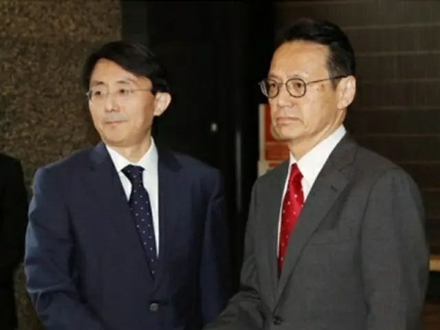 ６月５日、日本外務省で握手を交わす金氏（左）と金杉氏＝（共同＝聯合ニュース）