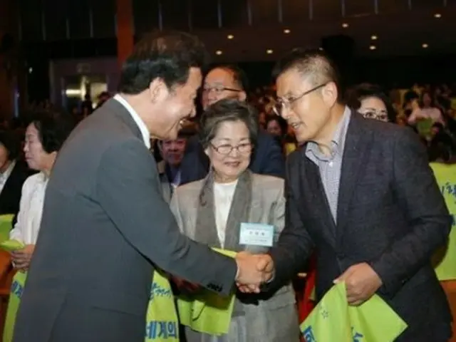 10月31日にソウル市内で開かれた全国女性大会で握手を交わす李氏（左）と黄氏＝（聯合ニュース）