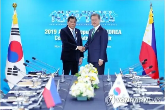 握手を交わす文大統領（右）とドゥテルテ大統領＝２５日、釜山（聯合ニュース）