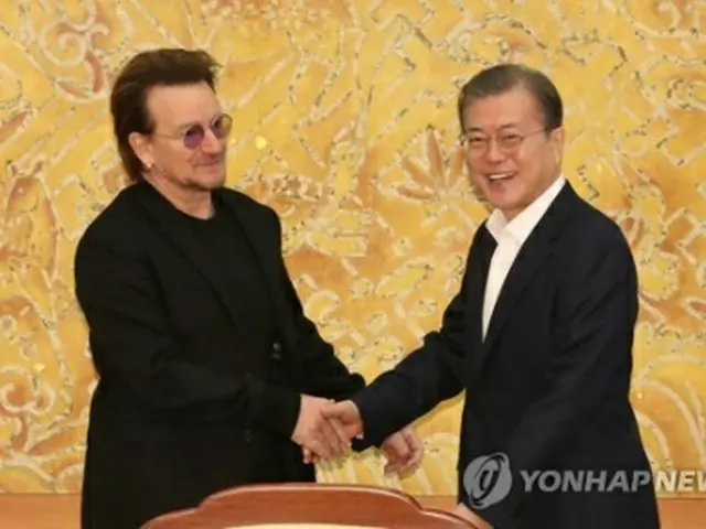 握手する文大統領（右）とボノさん＝9日、ソウル（聯合ニュース）