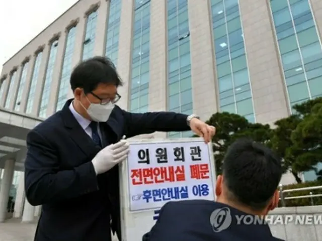 国会議員会館の前で閉鎖の案内を掲示する関係者ら＝２4日、ソウル（聯合ニュース）