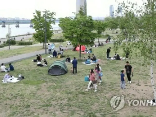 日曜日の３日、漢江沿いでピクニックを楽しむ人々＝（聯合ニュース）