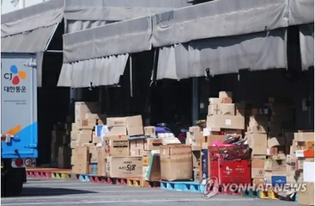 感染者の発生により一時閉鎖された宅配大手の市内の拠点に、配達待ちの荷物が積み重なっている＝11日、ソウル（聯合ニュース）