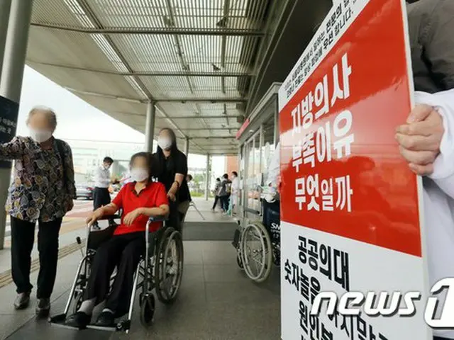 韓国で全国的な医師たちによるストライキが実施されている中、ソウルの病院の入り口で専攻医が政府の政策に反対するパネルを掲げている（提供:news1）