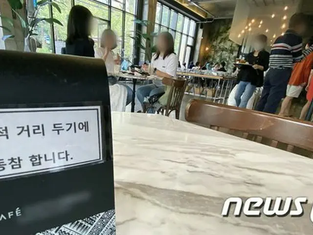 13日の韓国ソウル市内のカフェの様子。「ソーシャルディスタンスを守ろう」という看板が出されている（画像提供:wowkorea）