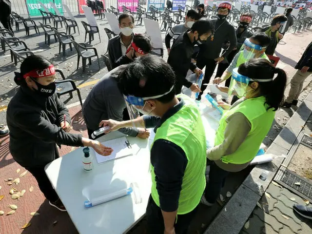 4日午後、ソウル市において全国民主労働組合総連盟（民主労総）主催で開かれた‘チョン・テイル50周忌烈士精神継承全国労働者大会’を前に、集会参加者らが体温測定を行っている（画像提供:wowkorea）
