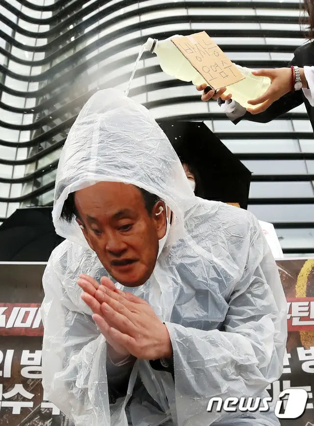 「放射能汚染水」と書かれた水を菅首相のお面をかぶった人物にかけるパフォーマンスを実施。（画像提供:wowkorea）