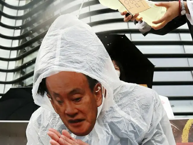 「放射能汚染水」と書かれた水を菅首相のお面をかぶった人物にかけるパフォーマンスを実施。（画像提供:wowkorea）
