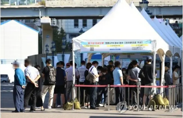 ソウル駅前の広場に設置されている臨時検査所で、市民が順番を待っている＝23日、ソウル（聯合ニュース）
