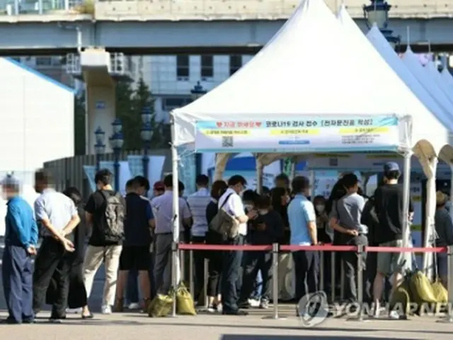 ソウル駅前の広場に設置されている臨時検査所で、市民が順番を待っている＝23日、ソウル（聯合ニュース）
