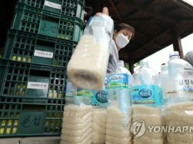 北朝鮮に送るコメをペットボトルに入れるクンセムの関係者（資料写真）＝（聯合ニュース）