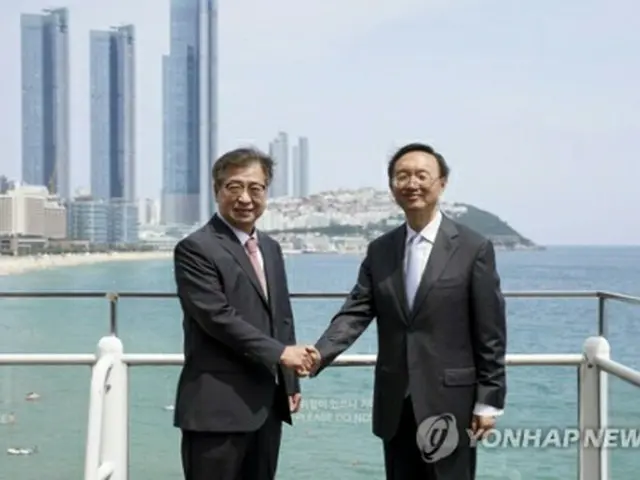 昨年８月２２日、釜山で会談後、握手を交わす徐氏（左）と楊氏（資料写真）＝（聯合ニュース）
