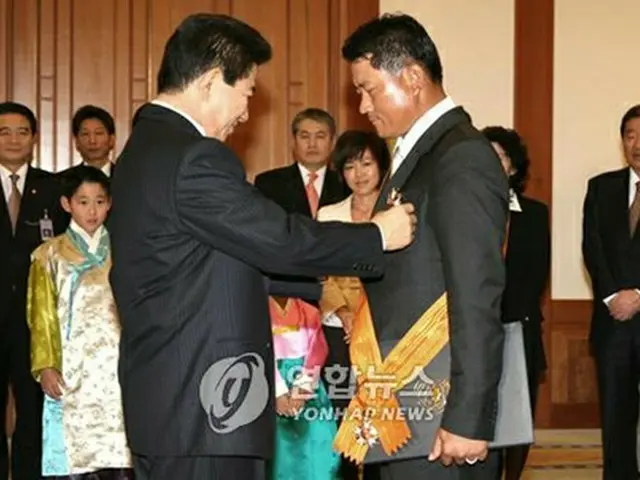 盧武鉉大統領から体育勲章を授与されるチェ・ギョンジュ選手＝23日、ソウル（聯合）