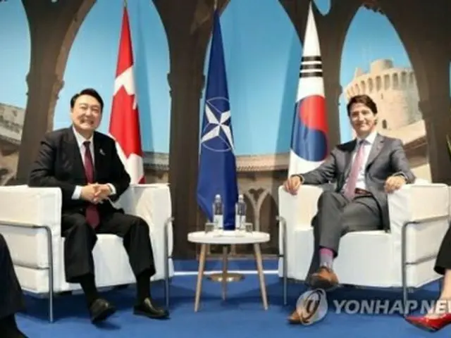 会談で笑顔を見せる尹大統領とトルドー首相＝３０日、マドリード（聯合ニュース）