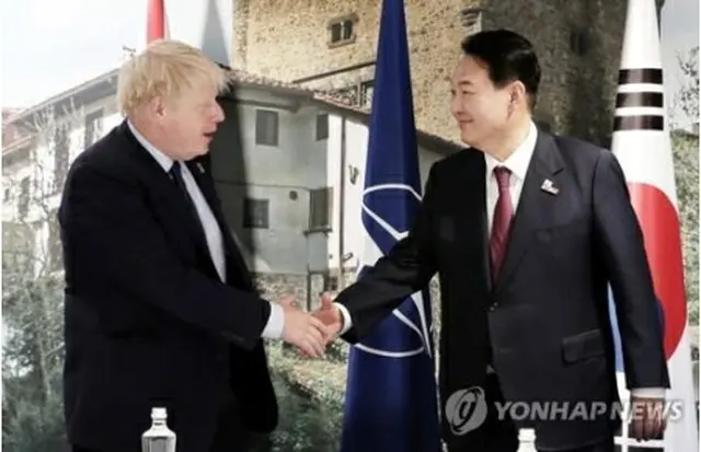 握手を交わす尹大統領とジョンソン首相＝３０日、マドリード（聯合ニュース）