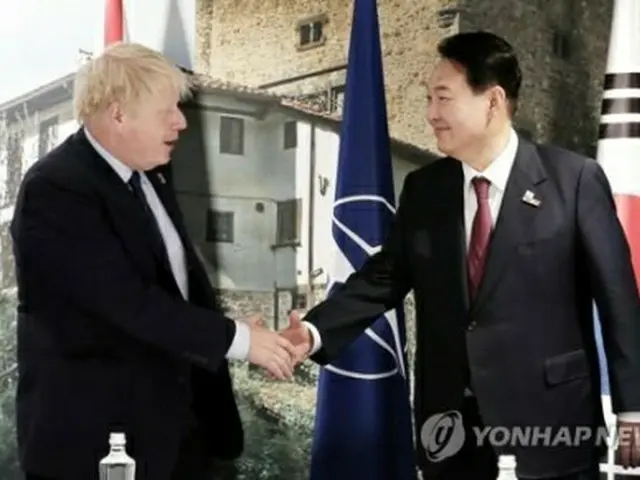 握手を交わす尹大統領とジョンソン首相＝３０日、マドリード（聯合ニュース）