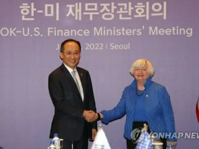 握手する秋氏(左)とイエレン氏(共同取材)=19日、ソウル(聯合ニュース)