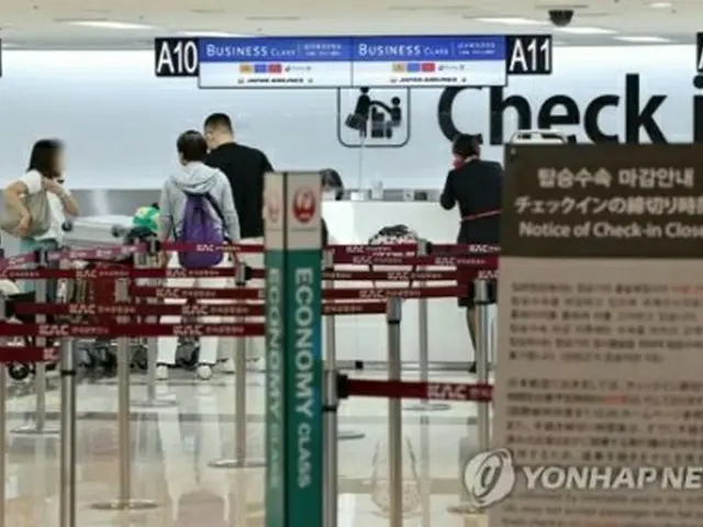 24日、金浦空港で羽田行きの飛行機の搭乗手続きをする乗客ら＝（聯合ニュース）