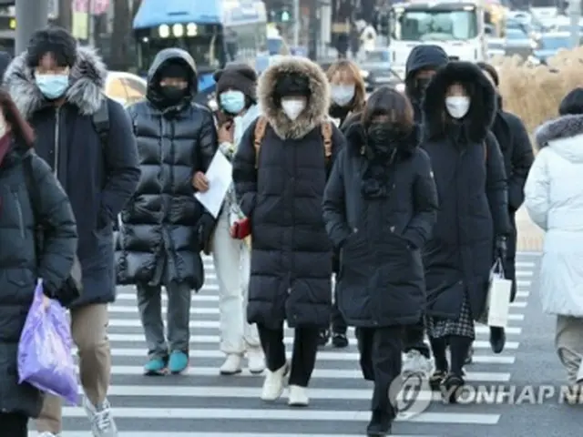 ソウル中心部の光化門広場を防寒着に身を包んだ人々が行き交っている＝25日、ソウル（聯合ニュース）