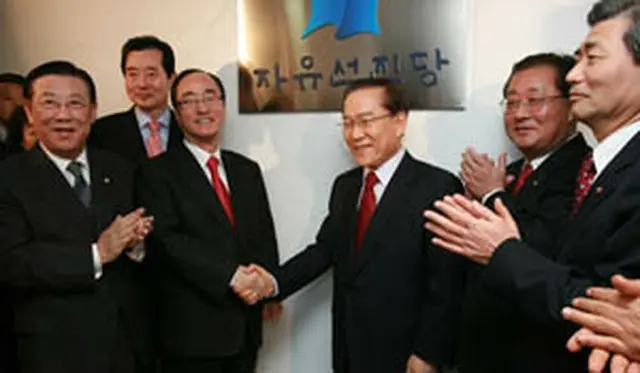 懸板式で握手する李総裁（右）と沈代表＝12日、ソウル（聯合）