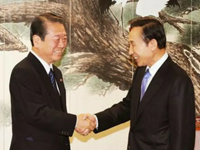握手を交わす小沢代表（左）と李次期大統領（共同取材団撮影）＝21日、ソウル（聯合）