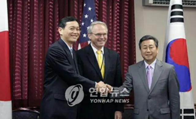 会合に先立ち握手を交わす韓米日首席代表＝19日、ワシントン（聯合）