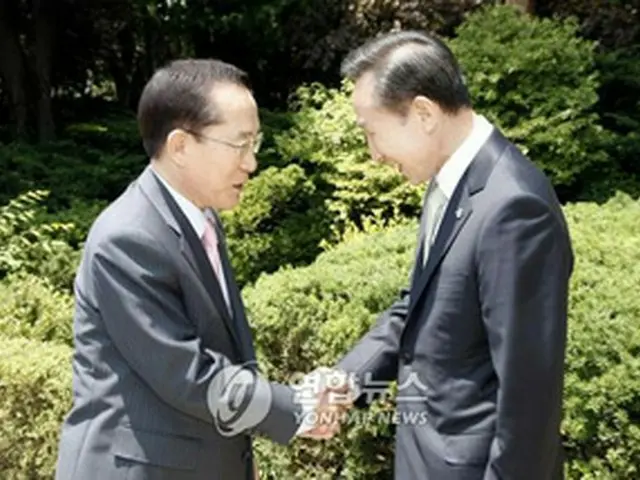 握手を交わす李大統領（右）と李総裁=15日、ソウル（聯合）