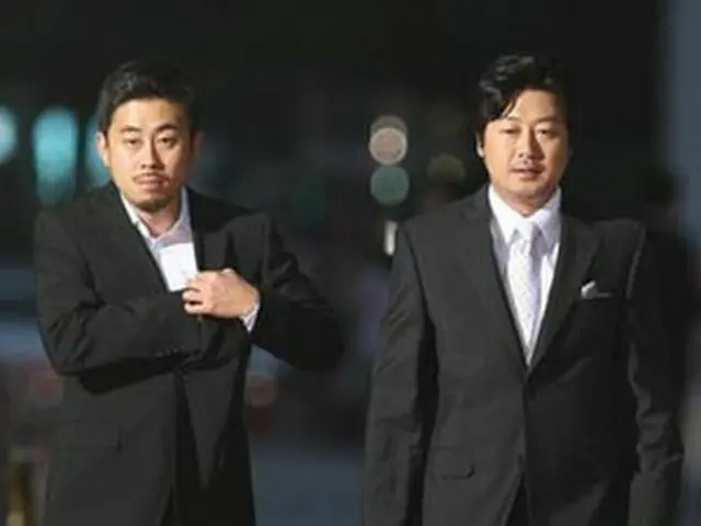 授賞式会場に入る「追撃者」のナ監督（左）とキム・ユンソク＝27日、ソウル（聯合）